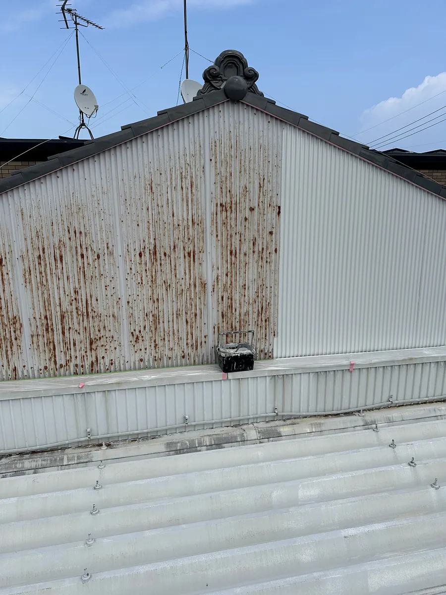 錆が縦に流れた波板（トタン）の妻壁。鶴田塗装の施工前